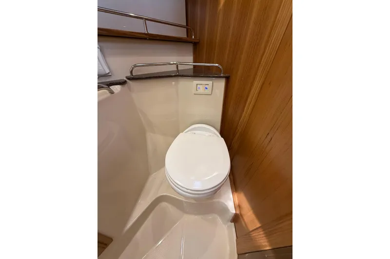 Slide: The Image of 2020 Ranger Tugs R-31 CB boat bathroom with modern toilet and wooden paneling. - 39