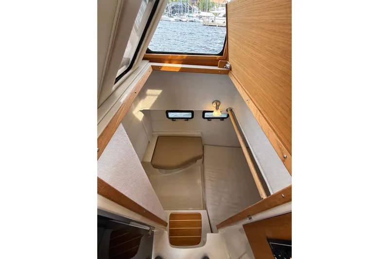 Slide: The Image of 2020 Ranger Tugs R-31 CB cabin interior with wood accents and small windows. - 44