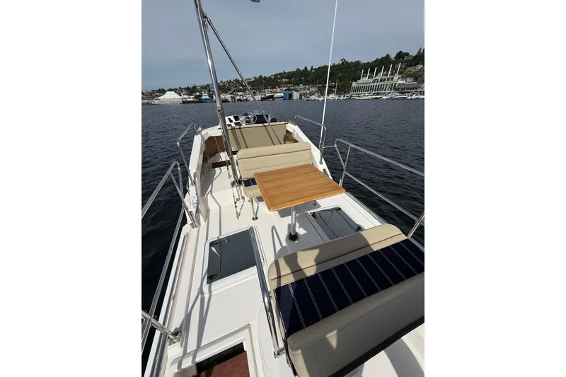 Slide: The Image of 2020 Ranger Tugs R-31 CB boat deck with seating and table on calm water. - 45