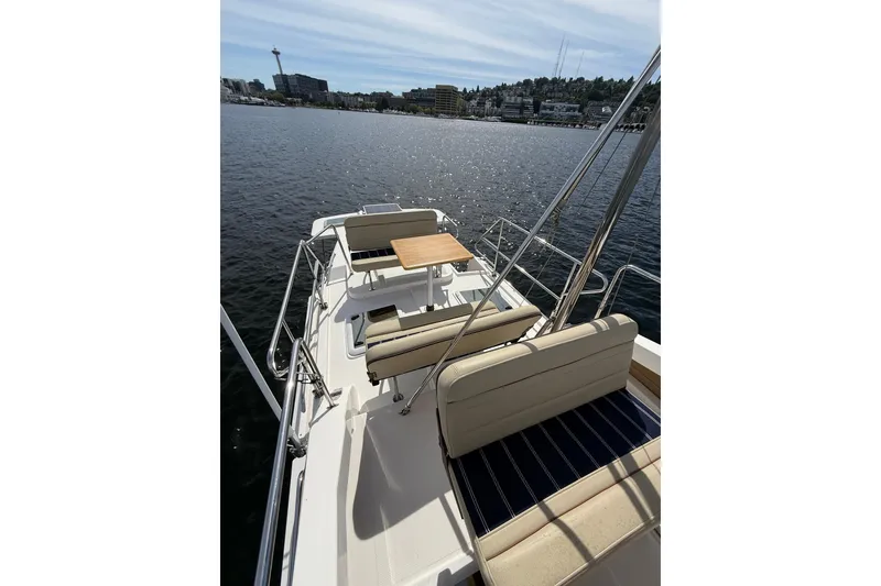 Slide: The Image of 2020 Ranger Tugs R-31 CB boat deck with seating and table on calm water. - 49