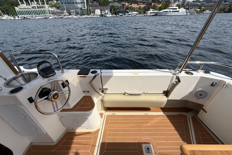 Slide: The Image of 2020 Ranger Tugs R-31 CB boat deck with steering wheel and waterfront view. - 9
