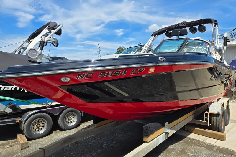 The Image of 2019 MasterCraft XT25 boat on trailer under blue sky. - 0