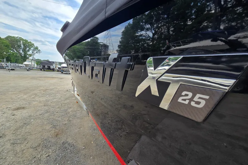 Slide: The Image of 2019 MasterCraft XT25 boat with reflective black exterior in a marina setting. - 11
