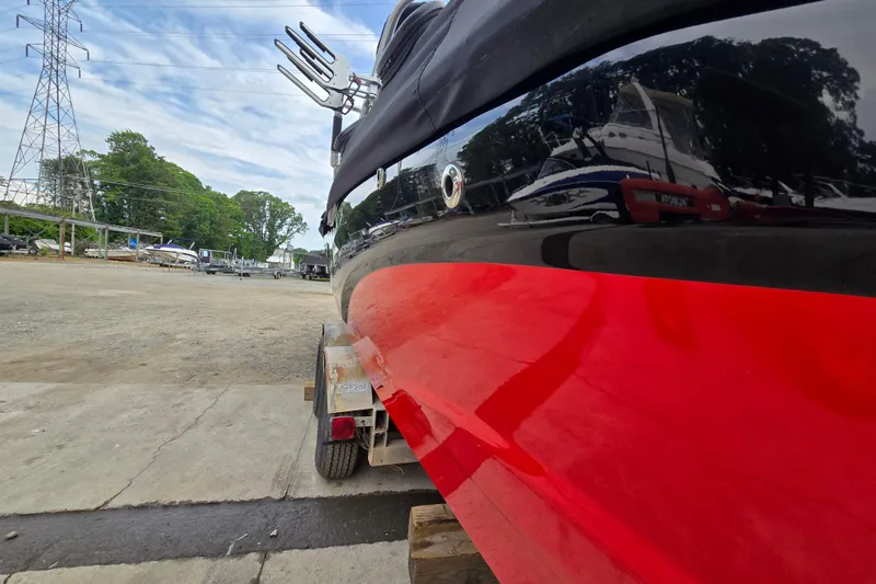 Slide: The Image of 2019 MasterCraft XT25 boat on trailer, vibrant red and black finish, outdoor setting. - 16