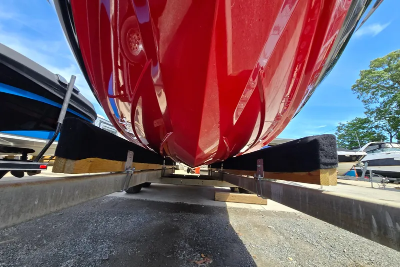 Slide: The Image of Red 2019 MasterCraft XT25 boat on trailer, viewed from below, in a marina setting. - 22