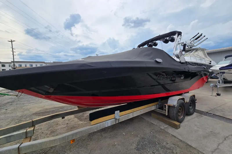 Slide: The Image of 2019 MasterCraft XT25 boat on trailer, covered, with black and red design. - 3
