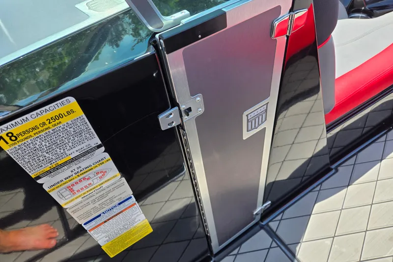 Slide: The Image of 2019 MasterCraft XT25 boat door with capacity label, black and red interior. - 38