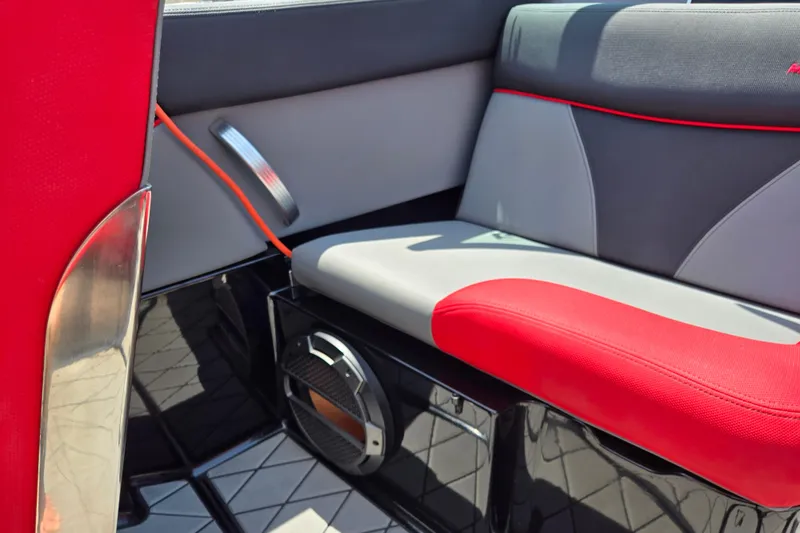 Slide: The Image of 2019 MasterCraft XT25 interior with red and gray seating, featuring a built-in speaker. - 40
