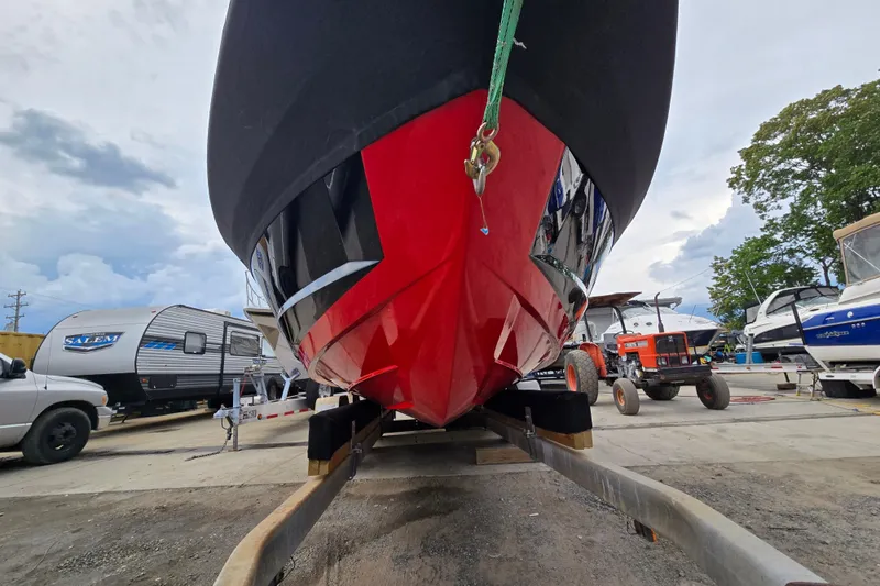 Slide: The Image of 2019 MasterCraft XT25 boat on trailer, vibrant red hull, parked in marina. - 5