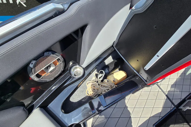 Slide: The Image of Interior of a 2019 MasterCraft XT25 boat showing storage compartment and speaker. - 51