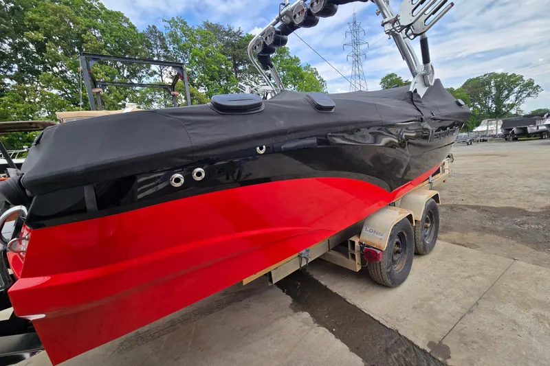 Slide: The Image of 2019 MasterCraft XT25 boat with red and black hull on a trailer. - 7