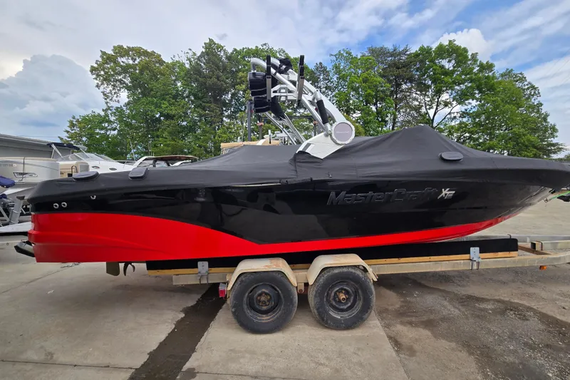 Slide: The Image of 2019 MasterCraft XT25 boat with black and red design on a trailer. - 8