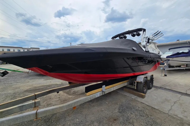 Slide: The Image of 2019 MasterCraft XT25 boat on trailer, black and red design, parked outdoors. - 9