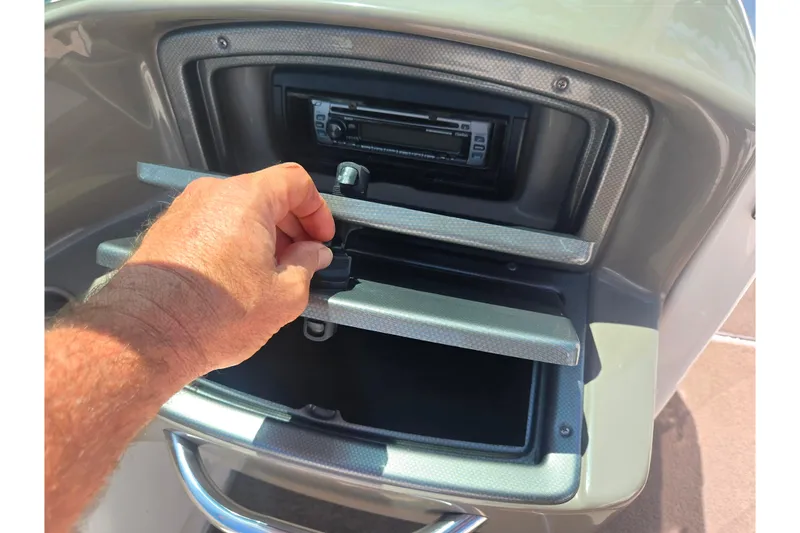 Slide: The Image of Hand opening storage compartment on 2008 Rinker 226 Captiva Bowrider boat dashboard. - 17