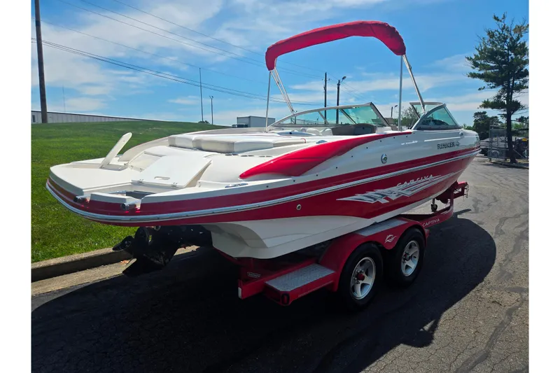 Slide: The Image of 2008 Rinker 226 Captiva Bowrider on trailer, red and white design, sunny day. - 3