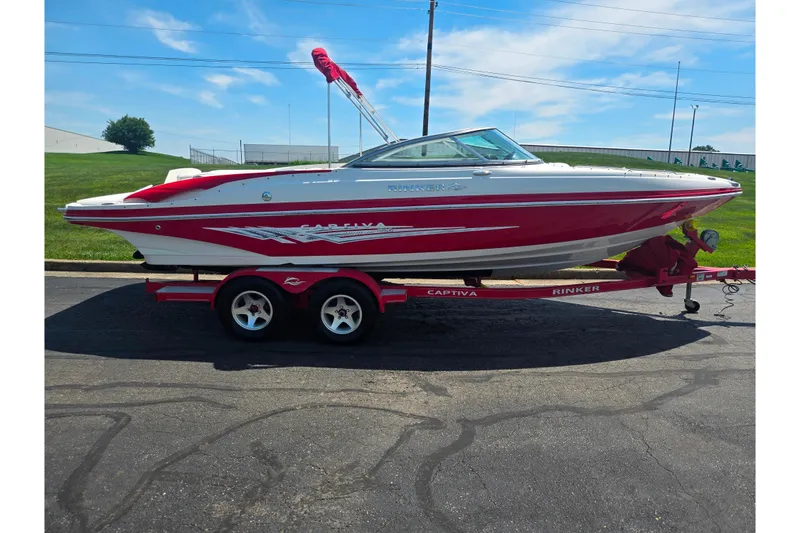 Slide: The Image of 2008 Rinker 226 Captiva Bowrider on trailer, red and white design, parked outdoors. - 4