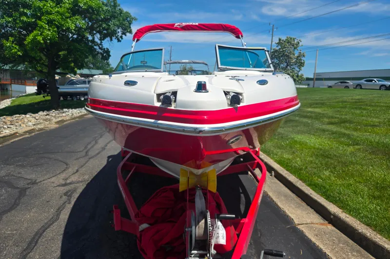 Slide: The Image of 2008 Rinker 226 Captiva Bowrider boat on trailer, red and white design, parked outdoors. - 6