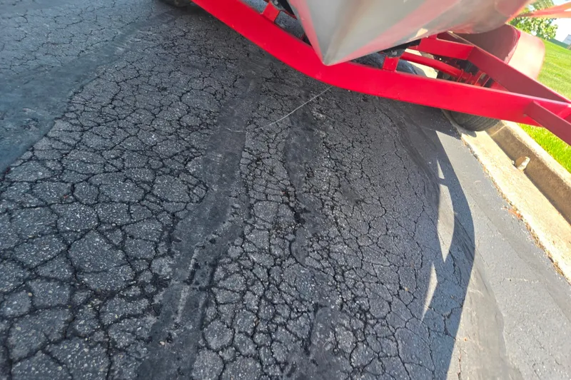 Slide: The Image of 2008 Rinker 226 Captiva Bowrider on red trailer, parked on cracked asphalt. - 7