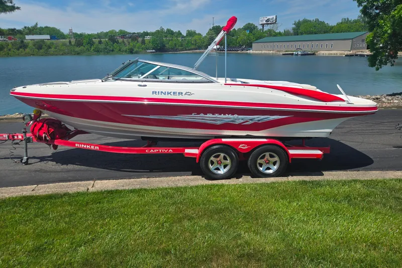 Slide: The Image of 2008 Rinker 226 Captiva Bowrider on trailer by a scenic lake. - 9