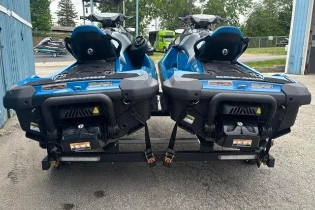 Slide: The Image of Two blue 2021 Seadoo GTI SE 130 jet skis parked on a trailer. - 2