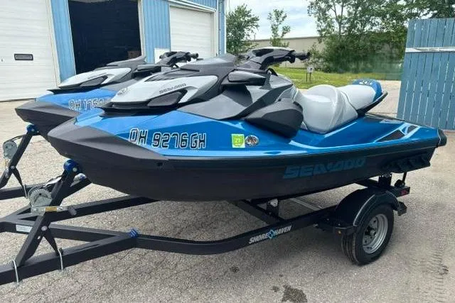 Slide: The Image of 2021 Seadoo GTI SE 130 jet skis on trailer, parked outdoors. - 3
