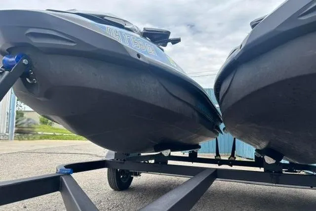 Slide: The Image of 2021 Seadoo GTI SE 130 jet skis on a trailer, parked outdoors. - 5