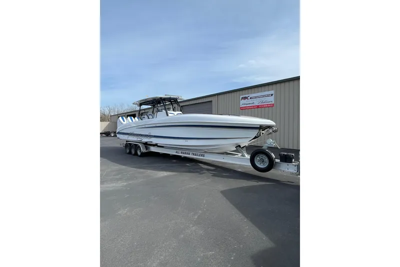 Slide: The Image of 2026 Renegade 38 Open boat on trailer, parked outside a building. - 2