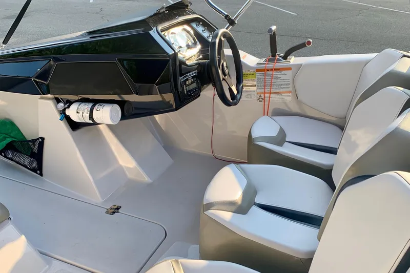 Slide: The Image of Interior of a 2015 Scarab 165 ID boat with steering wheel and seating. - 14