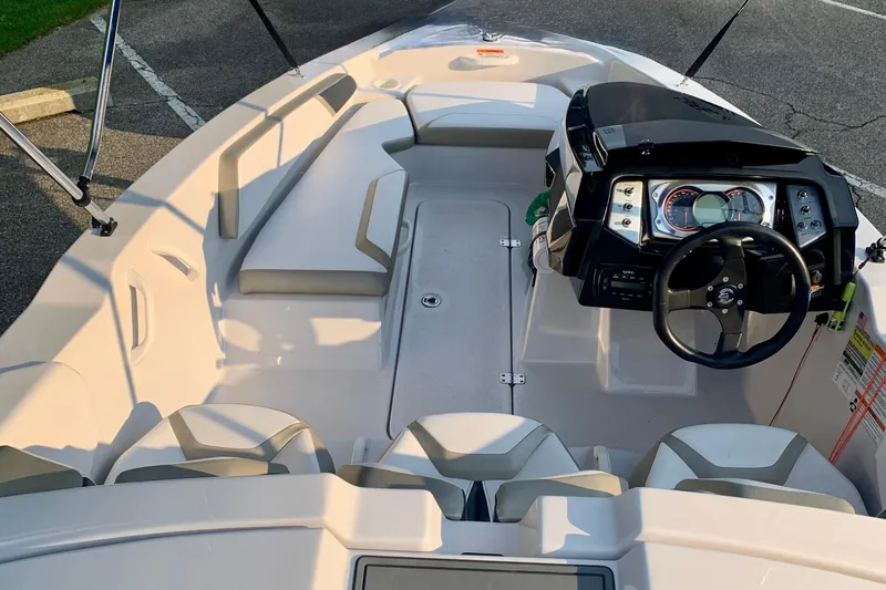 Slide: The Image of Interior view of a 2015 Scarab 165 ID boat, featuring seating and steering console. - 15