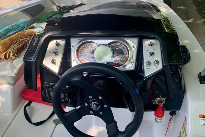 Slide: The Image of Dashboard of a 2015 Scarab 165 ID boat with steering wheel and controls. - 16