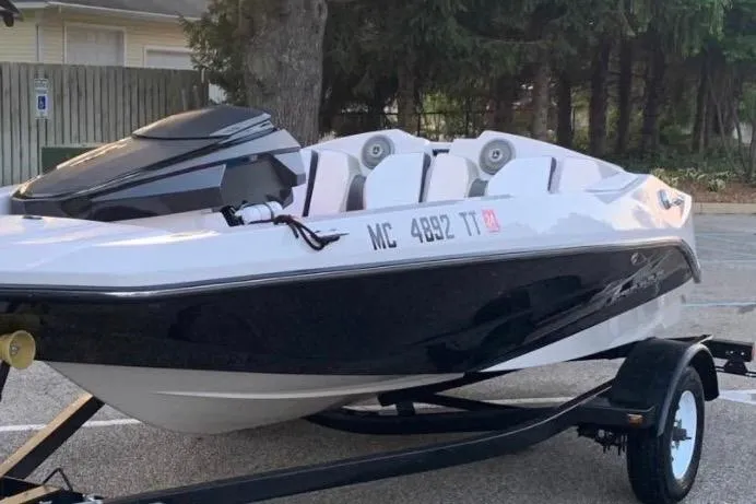 Slide: The Image of 2015 Scarab 165 ID boat on trailer, parked outdoors. - 2