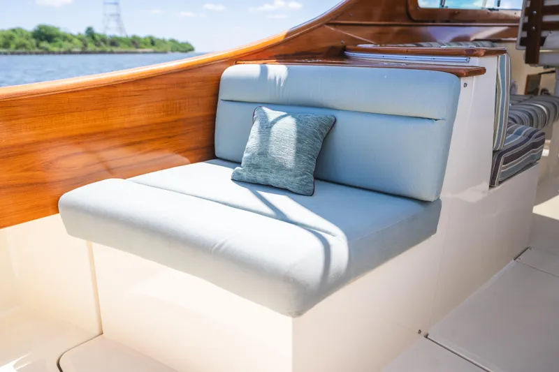 Slide: The Image of Luxurious seating on 2013 Hinckley Talaria 34 yacht with blue cushion and wooden accents. - 13