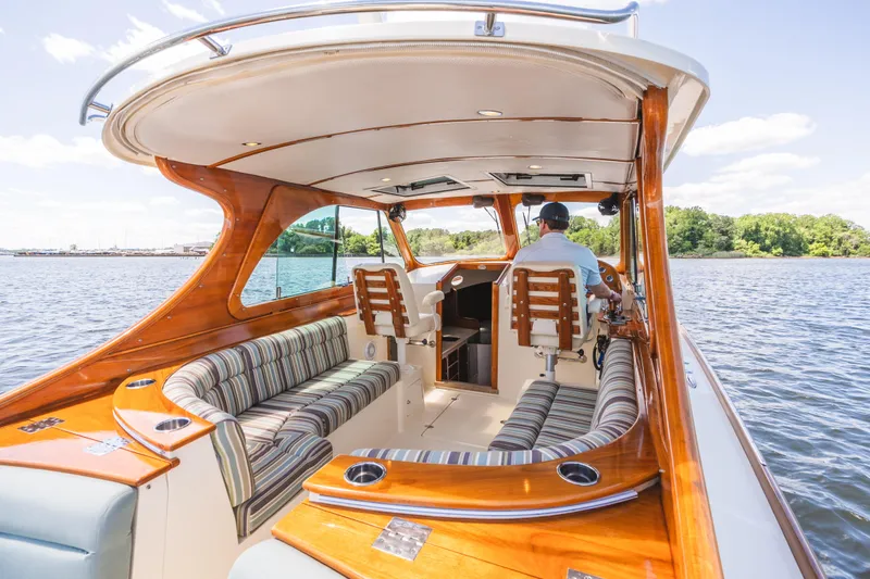 Slide: The Image of Luxurious 2013 Hinckley Talaria 34 boat interior with wood accents and striped seating on a sunny day. - 14