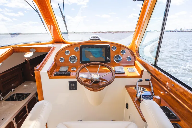 Slide: The Image of Helm of 2013 Hinckley Talaria 34 yacht with wooden accents and navigation equipment. - 22