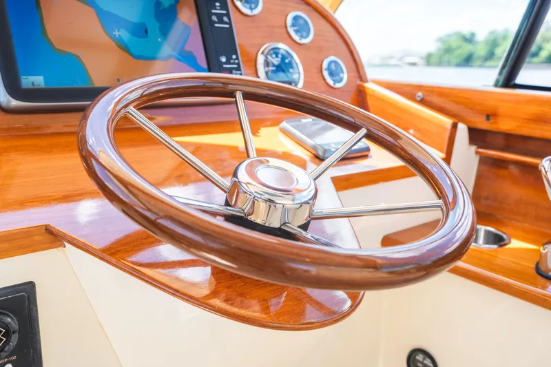 Slide: The Image of Steering wheel of 2013 Hinckley Talaria 34 boat with wooden dashboard and navigation screen. - 24