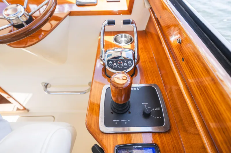Slide: The Image of Hinckley Talaria 34 helm controls, featuring polished wood and modern navigation equipment, 2013 model. - 25