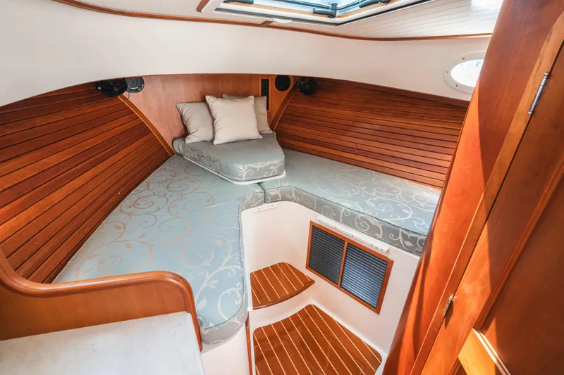 Slide: The Image of Hinckley Talaria 34 cabin interior, 2013 model, featuring elegant wood paneling and cozy bedding. - 33