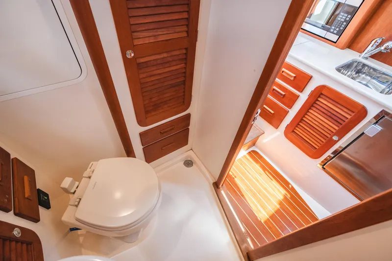 Slide: The Image of Interior of 2013 Hinckley Talaria 34 yacht, featuring a compact bathroom and kitchenette. - 36