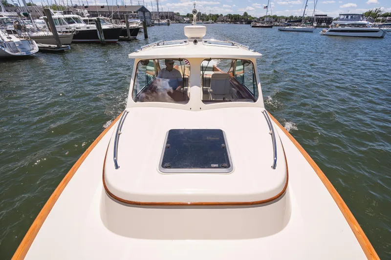 Slide: The Image of 2013 Hinckley Talaria 34 cruising in a marina with boats in the background. - 40
