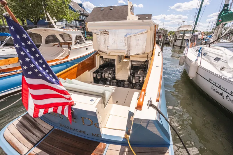 Slide: The Image of 2013 Hinckley Talaria 34 boat docked, displaying American flag, engine compartment open. - 41