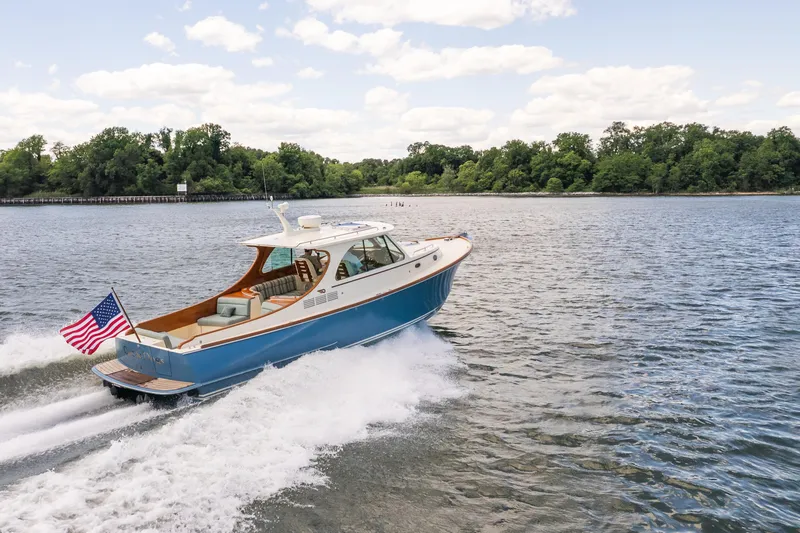 Slide: The Image of 2013 Hinckley Talaria 34 cruising on a scenic lake with American flag. - 44