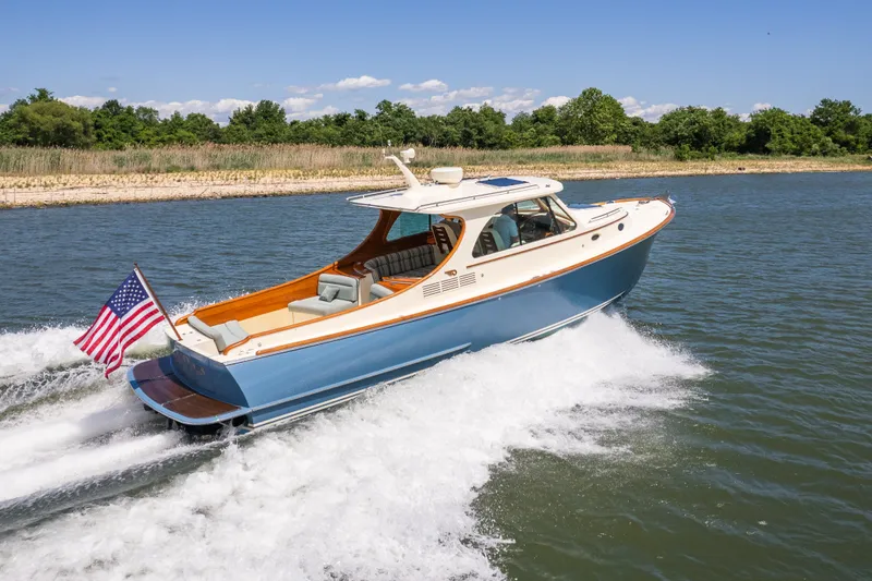Slide: The Image of 2013 Hinckley Talaria 34 cruising on a sunny day with American flag. - 8