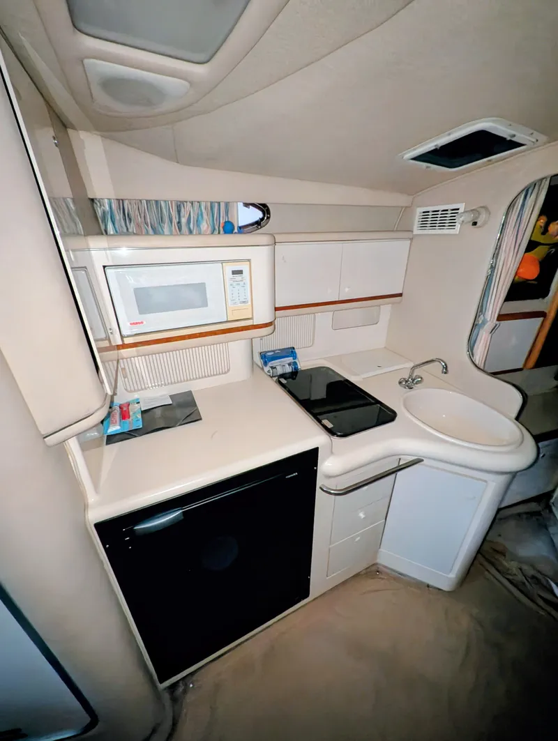 Slide: The Image of 1995 Sea Ray Sundancer 330 kitchen area with microwave and sink. - 10