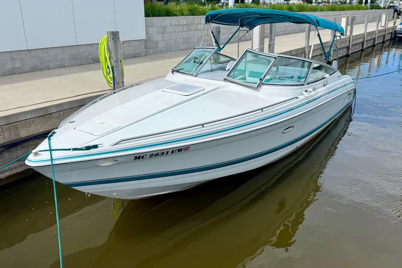The Image of 1995 Formula 280 Sun Sport boat docked with blue canopy and sleek design. - 1