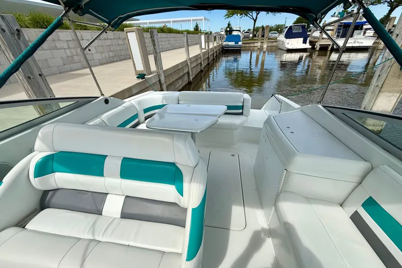 Slide: The Image of 1995 Formula 280 Sun Sport boat interior with white and teal seating at a marina. - 10