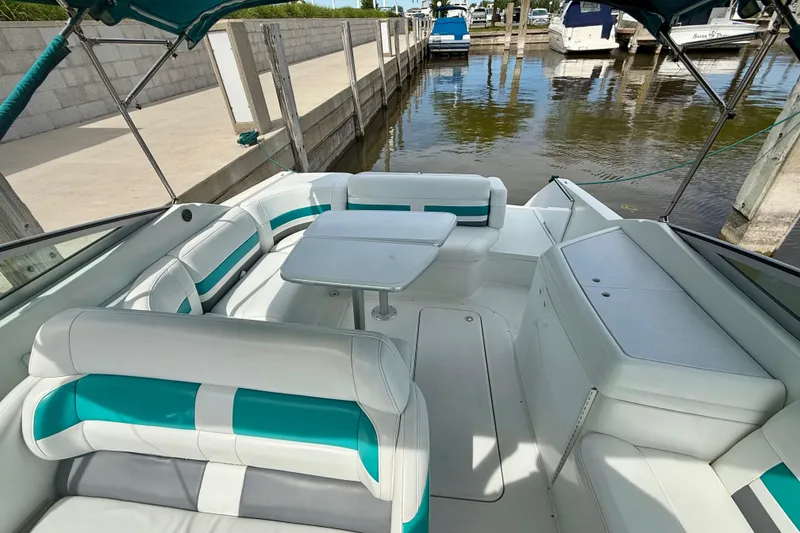 Slide: The Image of 1995 Formula 280 Sun Sport boat interior with teal and white seating at a marina. - 12