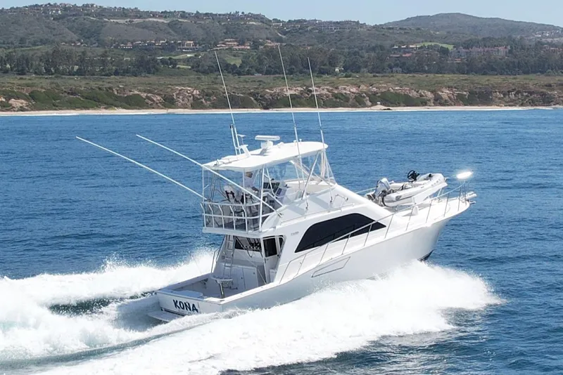 Slide: The Image of 2006 Cabo 40 Flybridge yacht cruising on blue ocean near scenic coastline. - 1