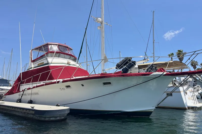 The Image of 1980 Egg Harbor 52 Convertible yacht docked, featuring red accents and clear blue sky. - 0