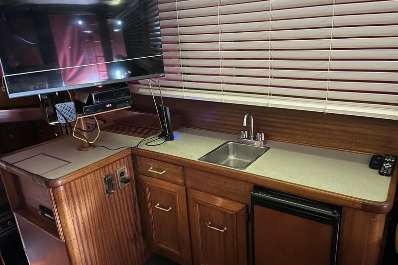 Slide: The Image of Kitchen area of a 1980 Egg Harbor 52 Convertible yacht with wooden cabinets. - 26