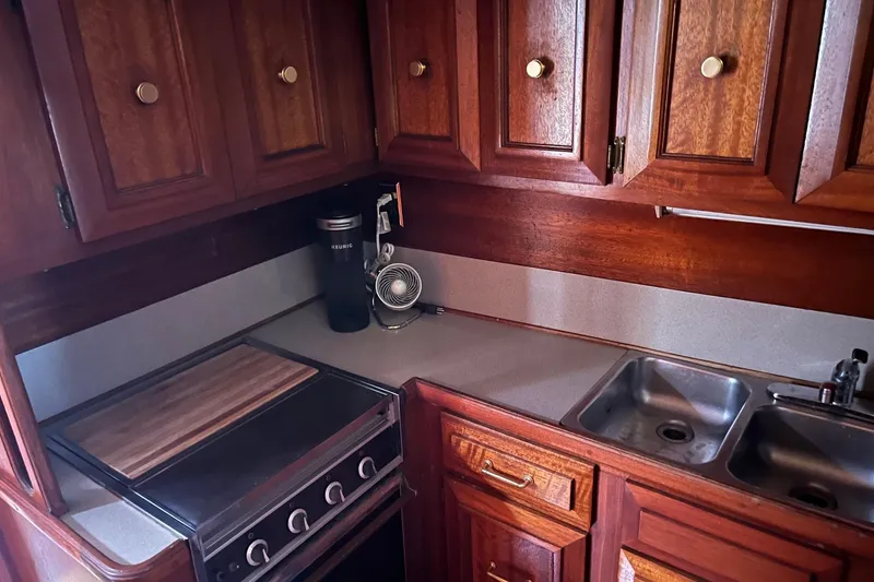 Slide: The Image of Kitchen area of 1980 Egg Harbor 52 Convertible yacht with wooden cabinets and refrigerator. - 27
